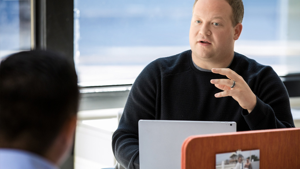 Ein Mann erklärt die Microsoft Lösung "plastische Reader" seinem Geschäftspartner.