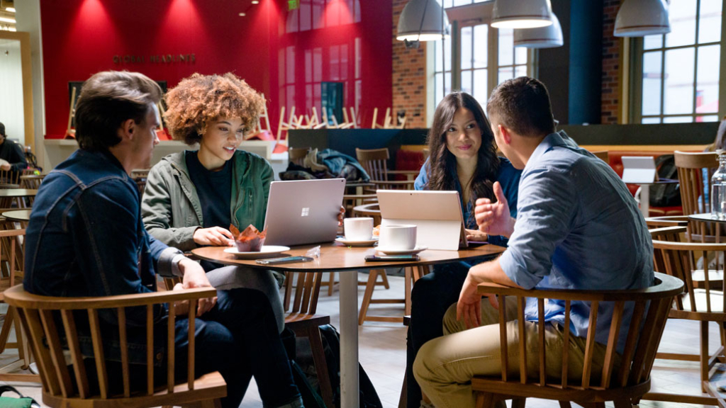 Eine Gruppe von Studenten sitzt in einem Cafe und unterhalten sich. Eine Gruppe von Studenten sitzt in einem Cafe und unterhalten sich.