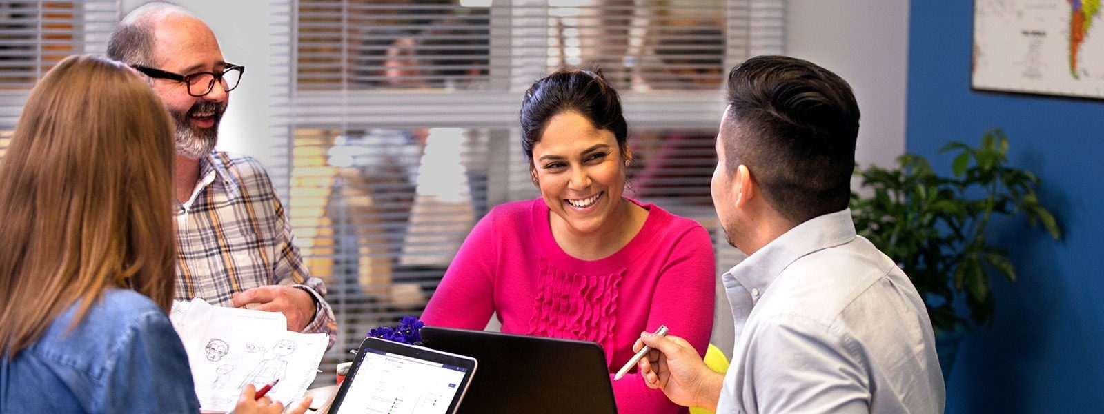 Lehrkräfte unterhalten sich sitzend an einem Tisch mit verschiedenen Devices.