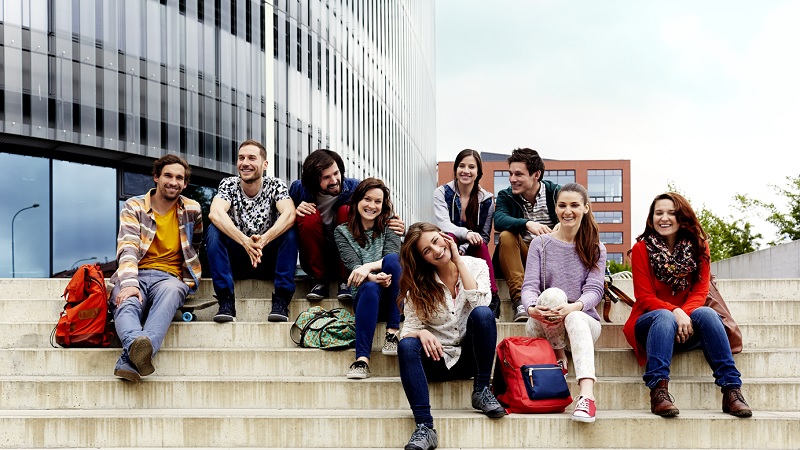 Schüler sitzen auf den Stufen ihrer Schule