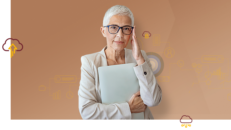 Eine Frau mit kurzen grauen Haaren hält vor sich einen zusammengeklappten Laptop