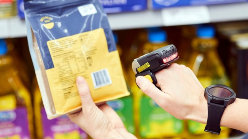 Auf dem Bild ist jemand zu sehen, der den Barcode einer Verpackung mit einem Ger&auml;t scannt