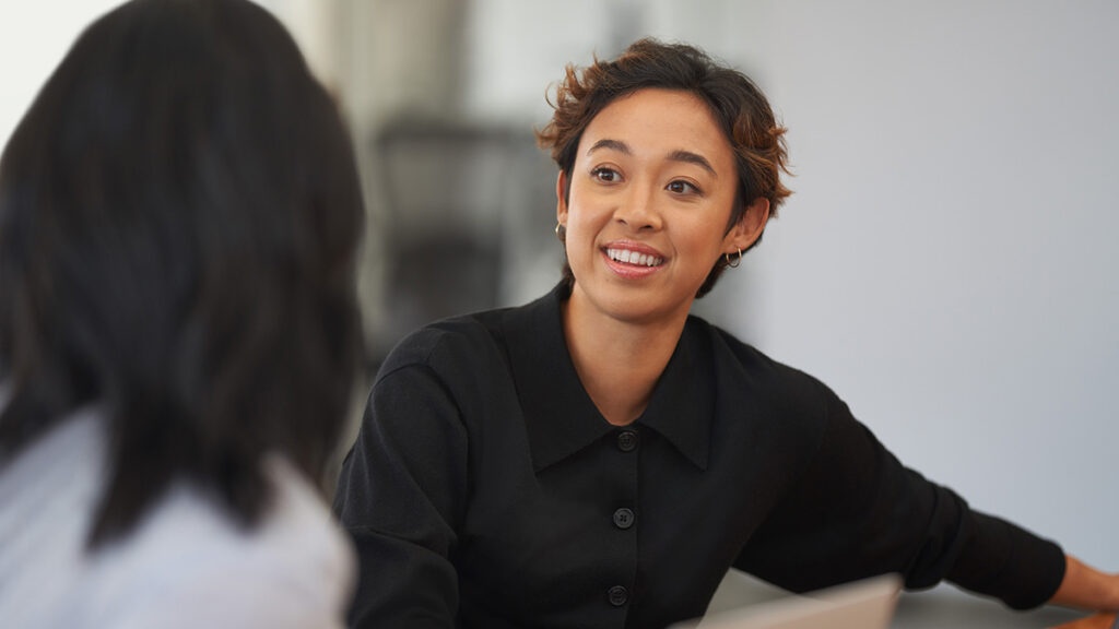A woman smiling at another woman