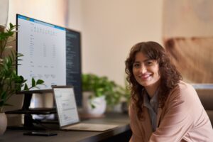 a woman standing in front of a laptop