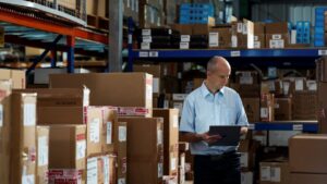 A man holding a tablet in a warehouse