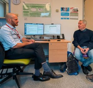 Doctor and patient conversing in a doctor's office.