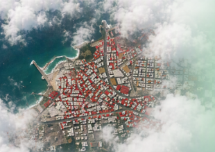 a birds-eye view of a disaster zone within a coastal city