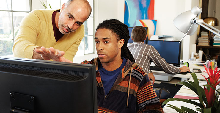 a man sitting in front of a laptop