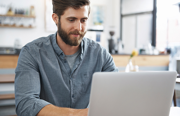 a man standing in front of a laptop