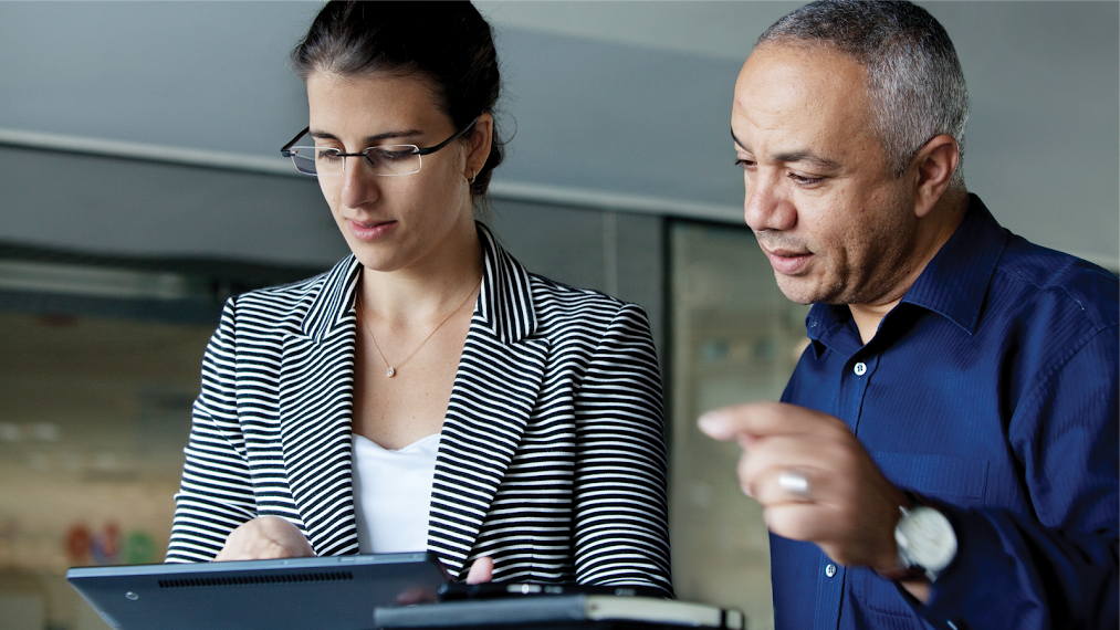 a man and a woman looking at a laptop