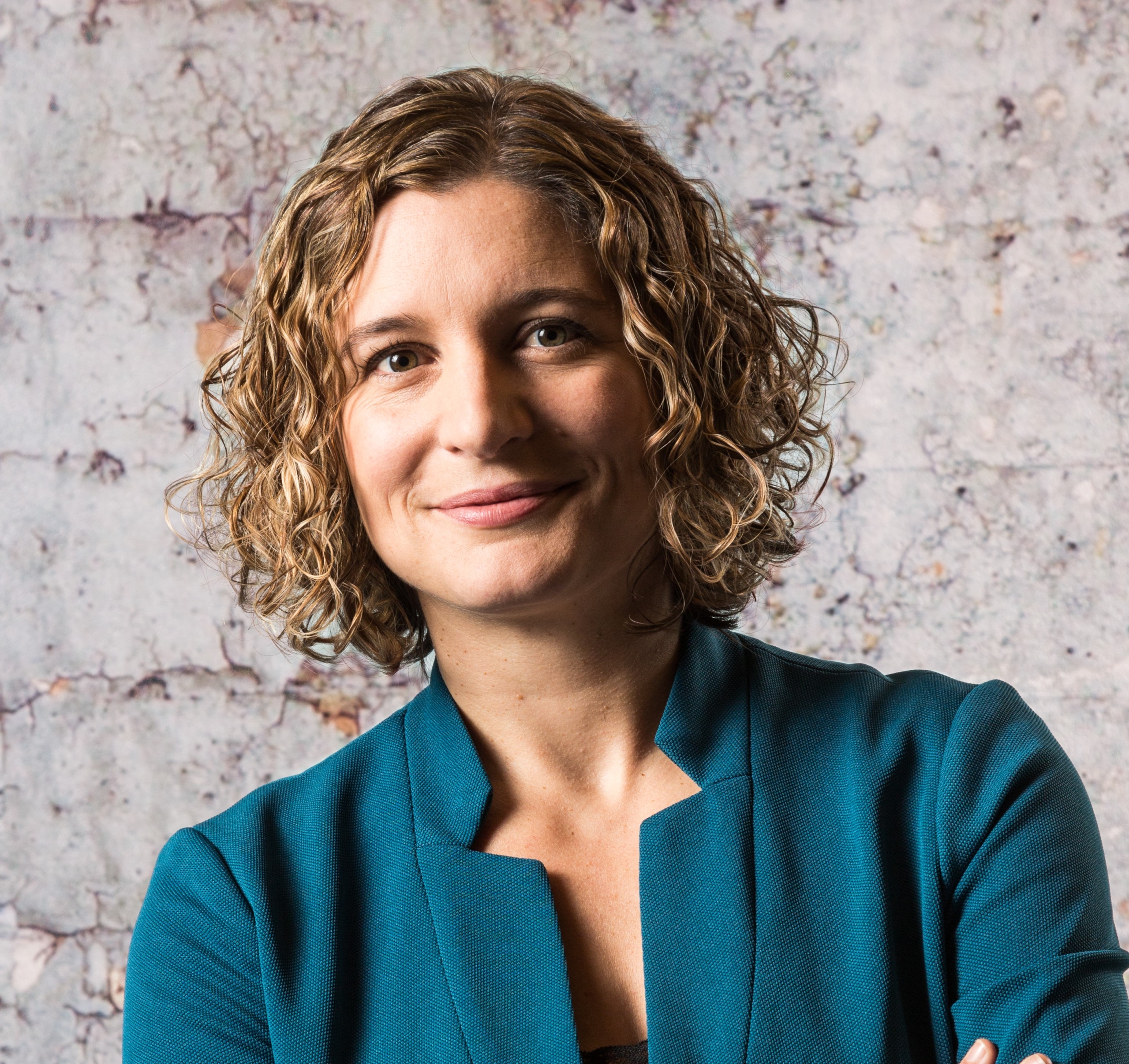 a person wearing a blue shirt and smiling at the camera