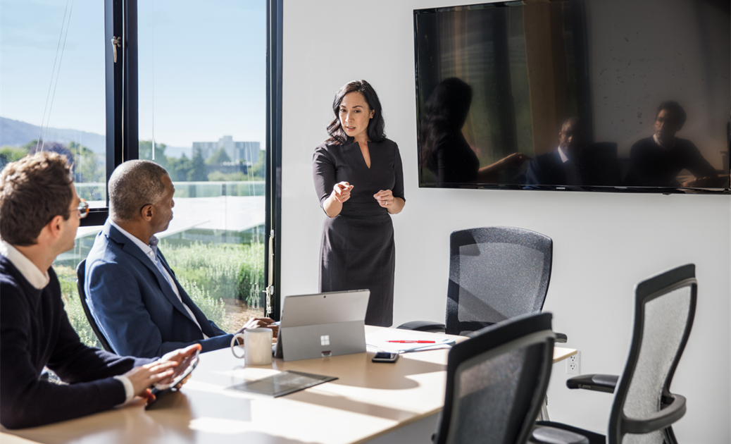a group of people sitting at a table with a laptop