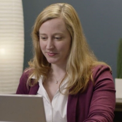 Kathleen Mulcahy standing in front of a laptop computer