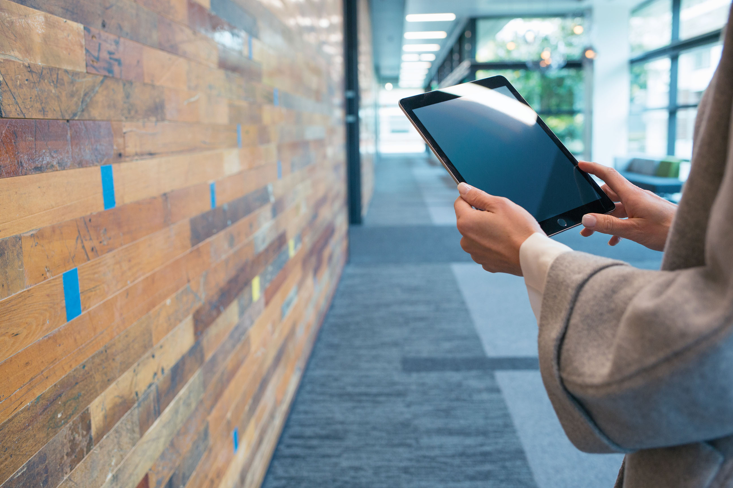 A persons arms holding a tablet.