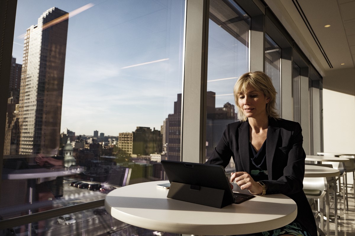 a person sitting at a table in front of a building