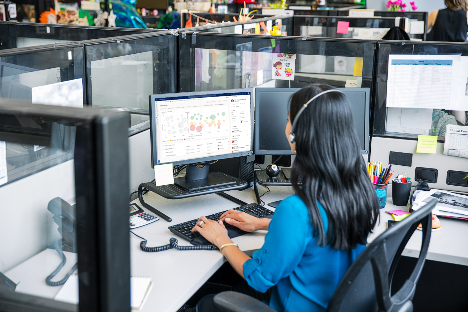 A person sitting at a desk in front of a computer using Dynamics 365 Sales