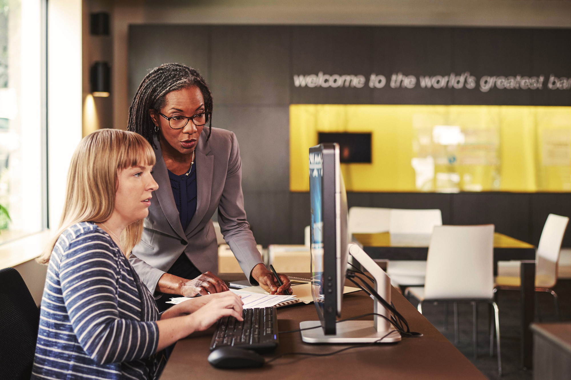 Photo of two female professionals working at a computer.