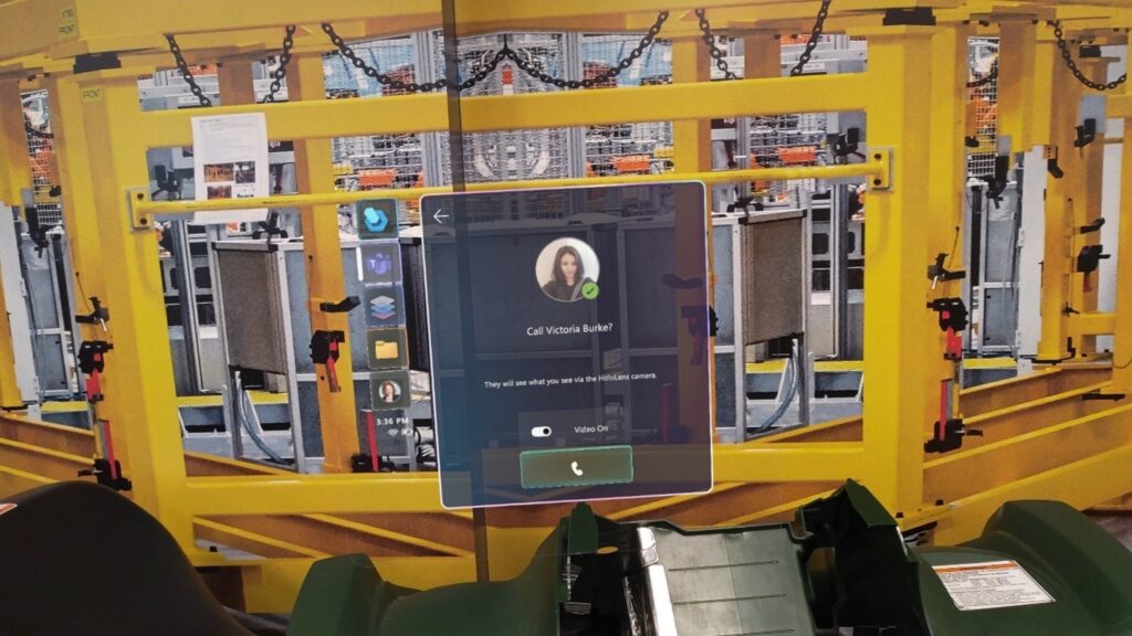 Photo of a Teams call window superimposed on a HoloLens user's view of a factory floor.