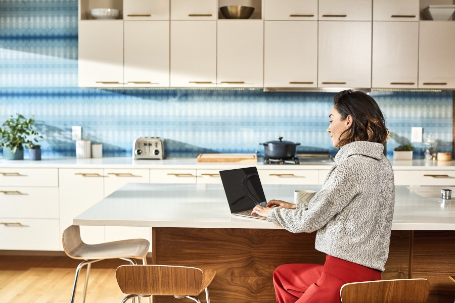 Woman working on large tile counter.