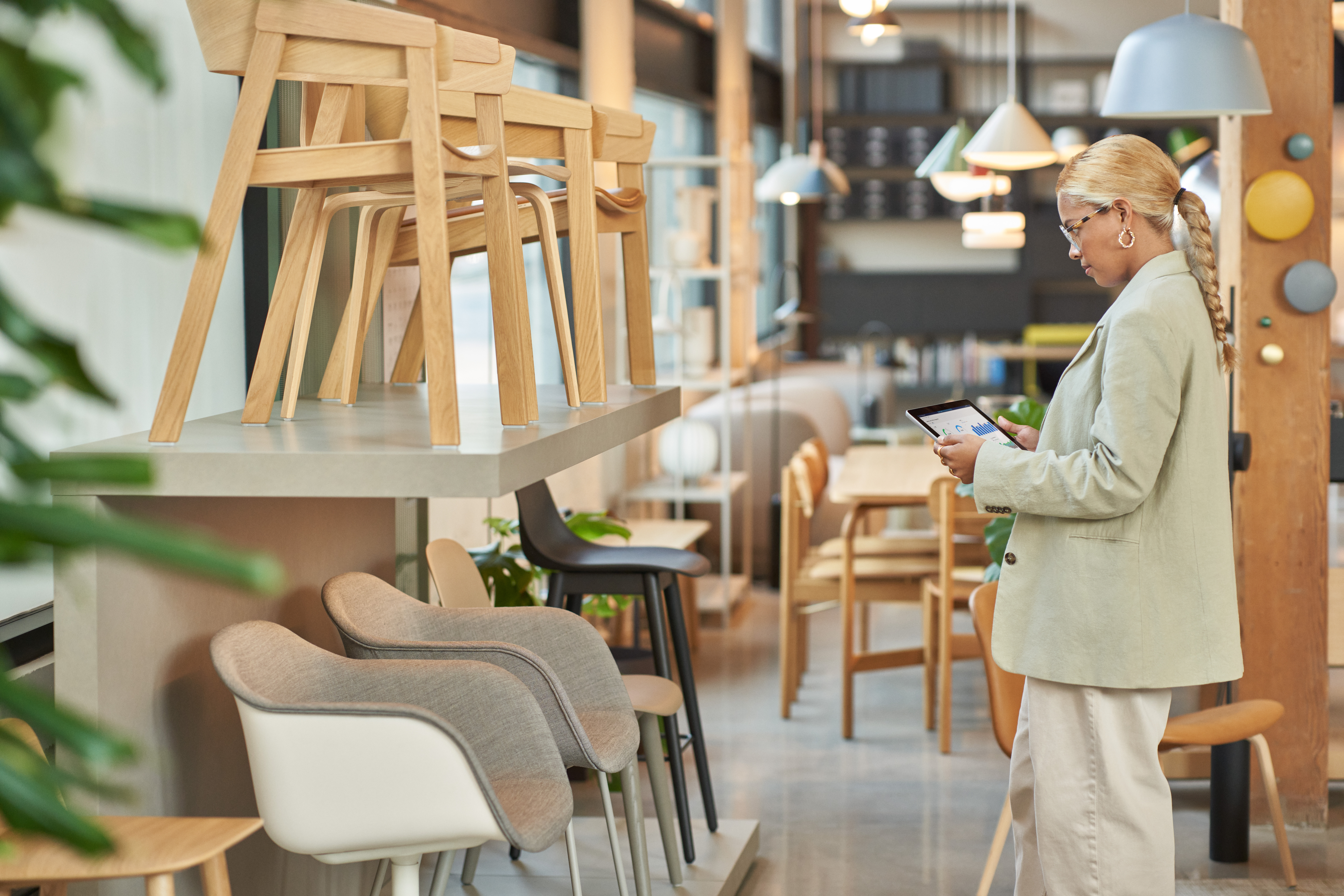 Photo of a female retail store manager using a tablet to review product information.