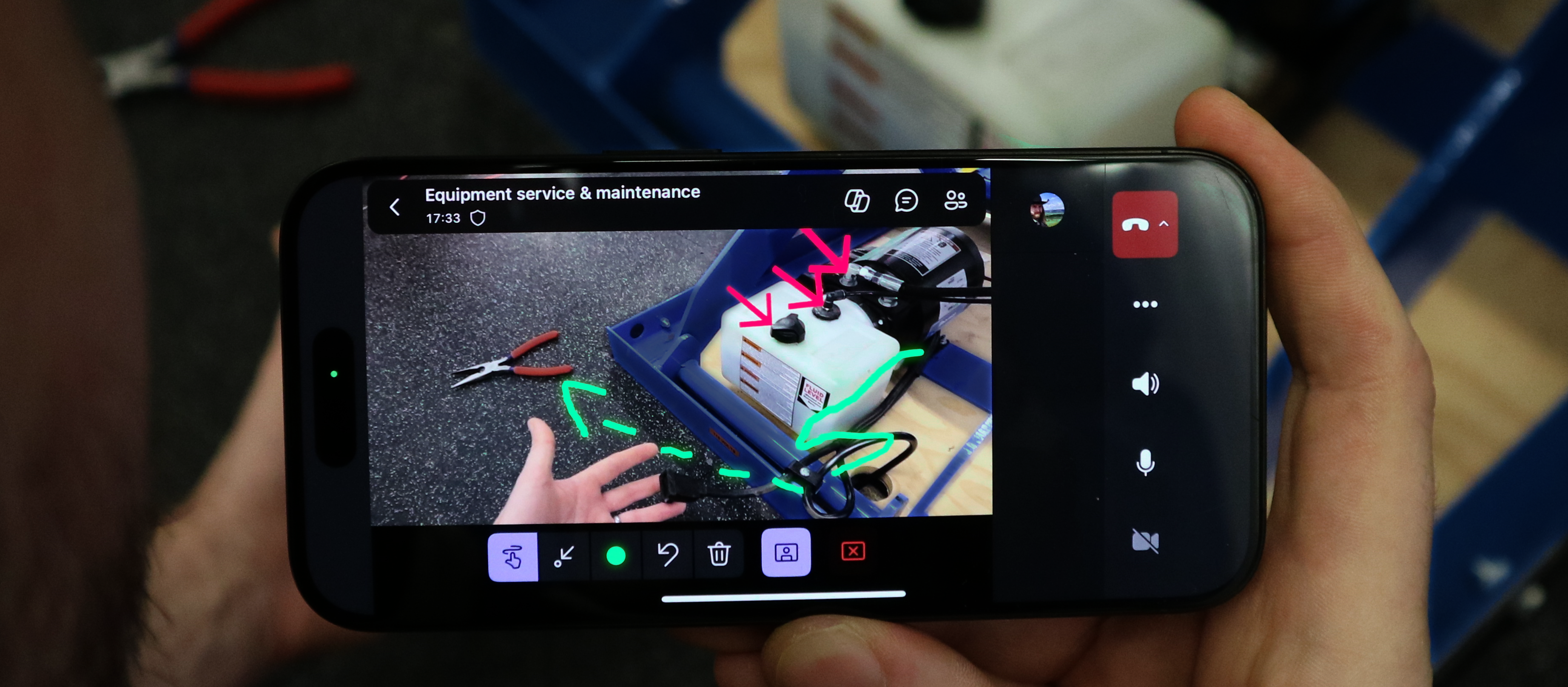 A hand holding a phone with a picture of a machine