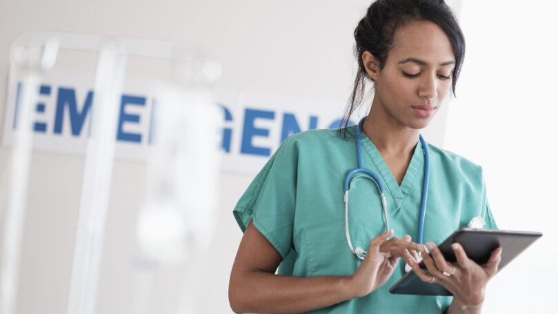 Nurse using a tablet for documentation in an emergency department.