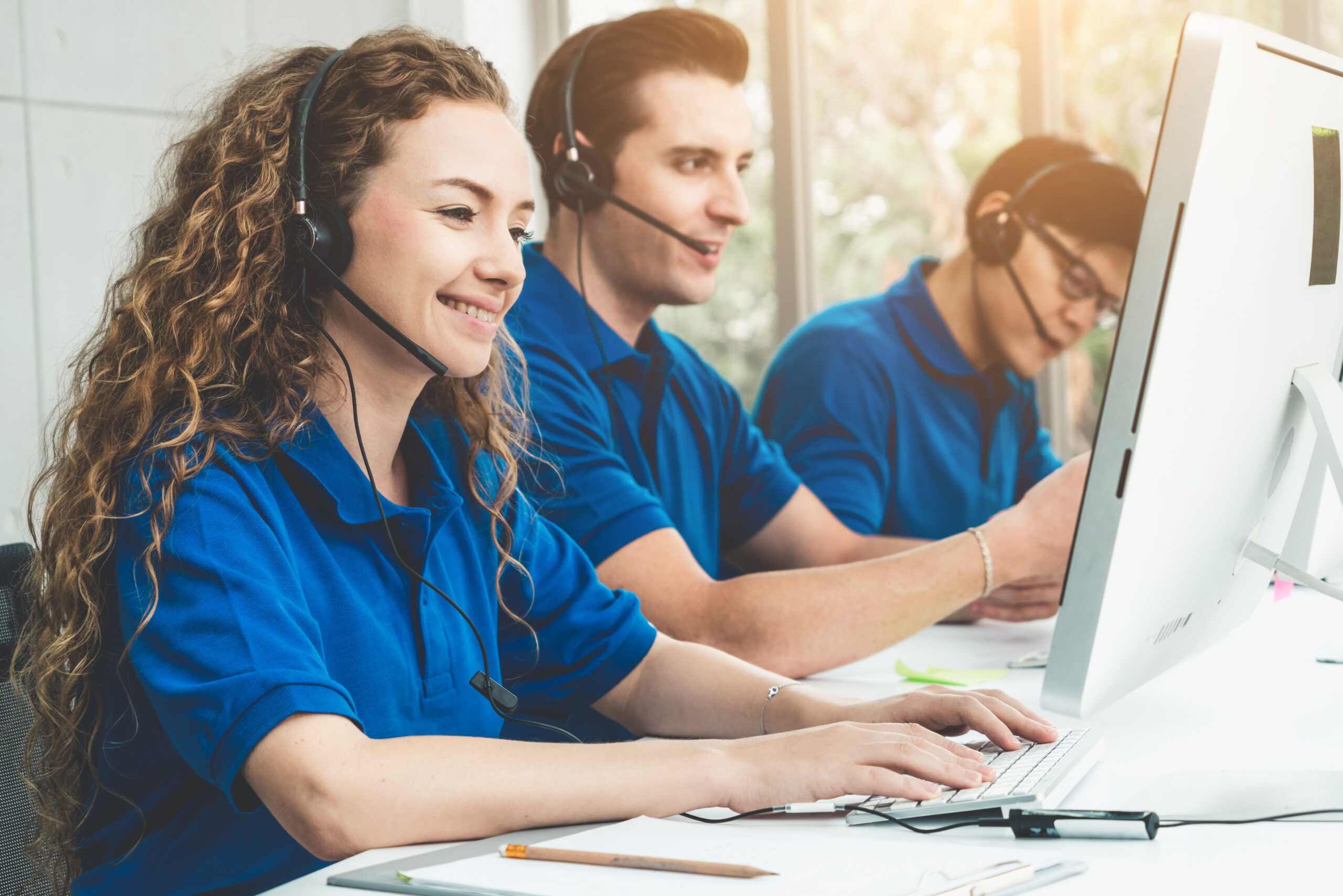 Business people wearing headset working in office to support remote customer or colleague. Call center, telemarketing, customer support agent provide service on telephone video conference call.