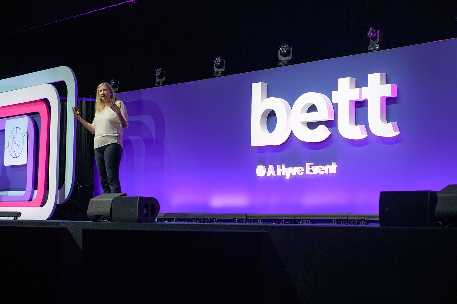 A conference presenter on stage delivering a keynote.