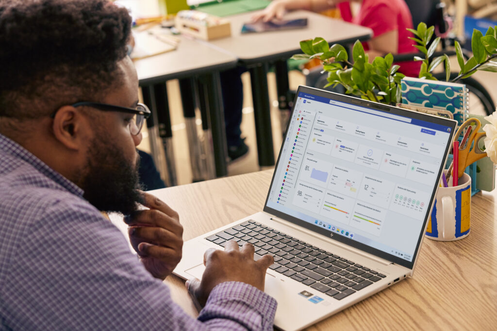 A teacher using Microsoft Teams on a laptop in a classroom.