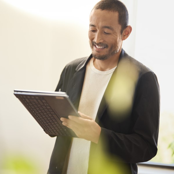 Decorative. An education leader writes on a folded 2-in-1 laptop with a digital pen.