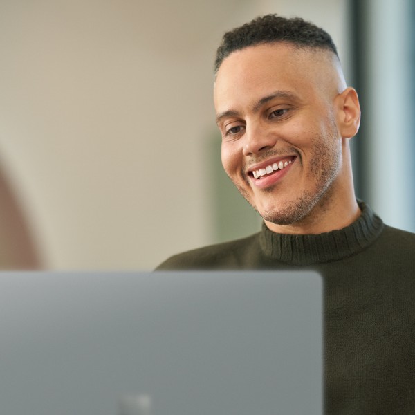 An IT professional works on a laptop in a school office.