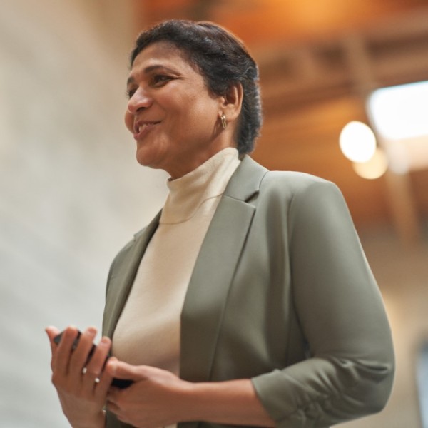 An education leader standing tall and smiling while looking toward something out of frame.