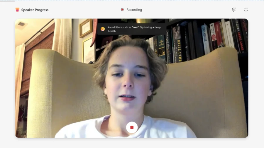 A student recording a Speaker Progress assignment with their laptop camera. A message on screen shows real-time, AI-powered feedback: Avoid fillers such as &lsquo;um&rsquo;. Try taking a deep breath.