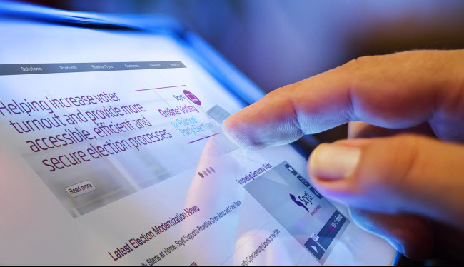 Hand using a touch screen voting booth