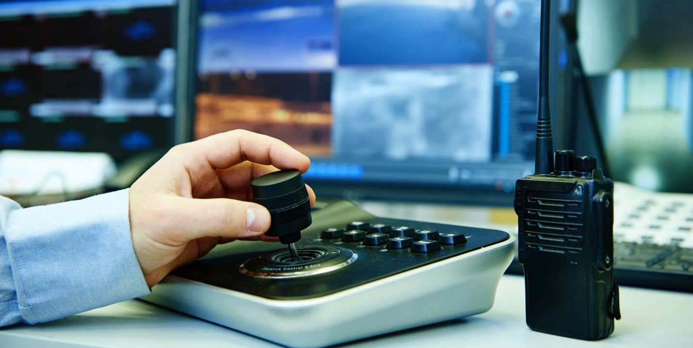 Hand using a surveillance keyboard with a joystick