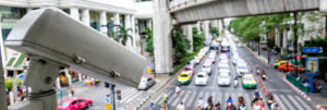 Close up CCTV security camera with blur of traffic jam