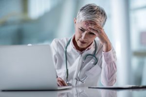 An image of a doctor looking exhausted.