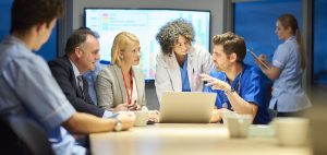 Two hospital managers listening to two doctors in conference room