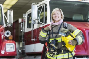 Female firefighter standing in front of fire truck