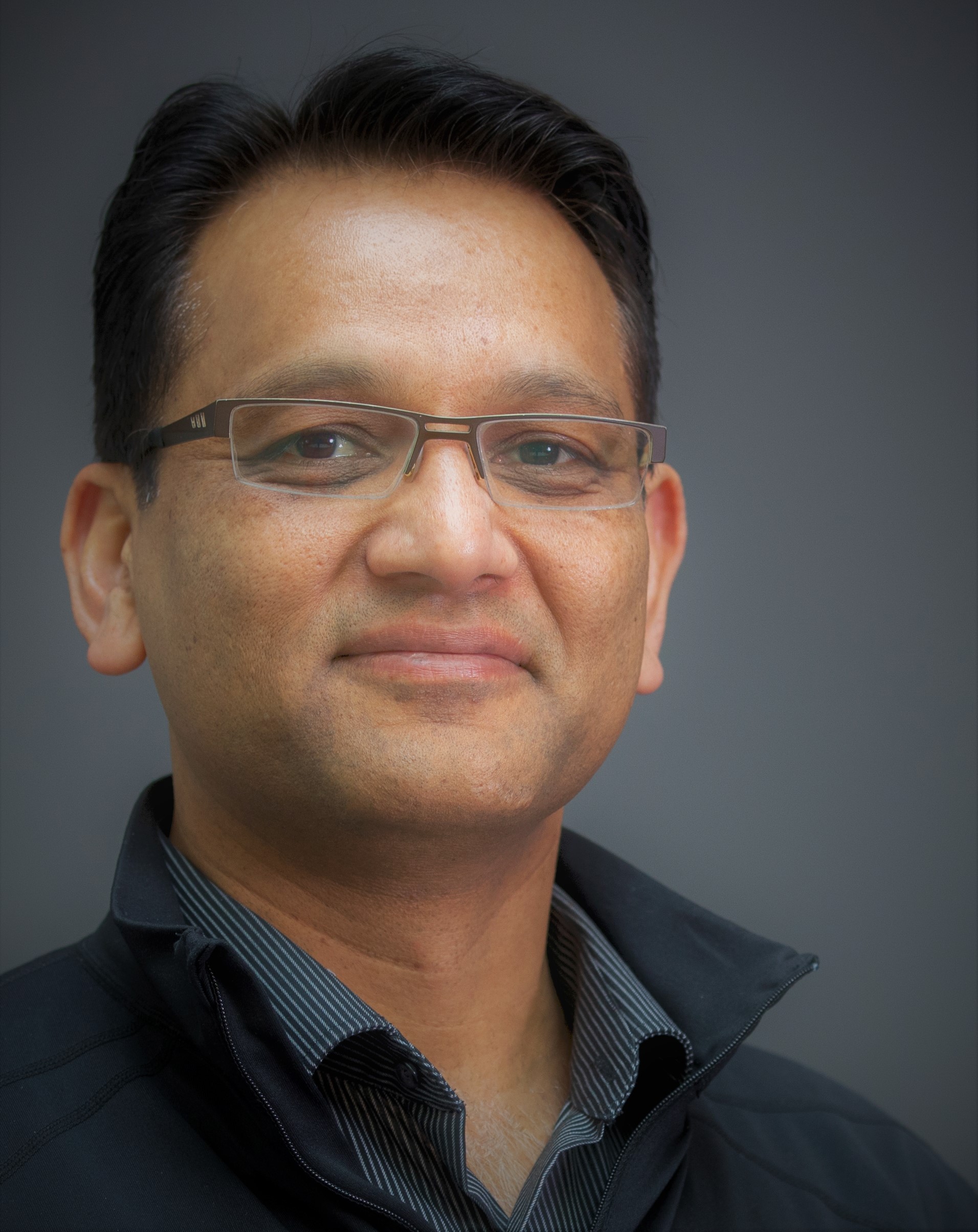 a man wearing glasses and looking at the camera