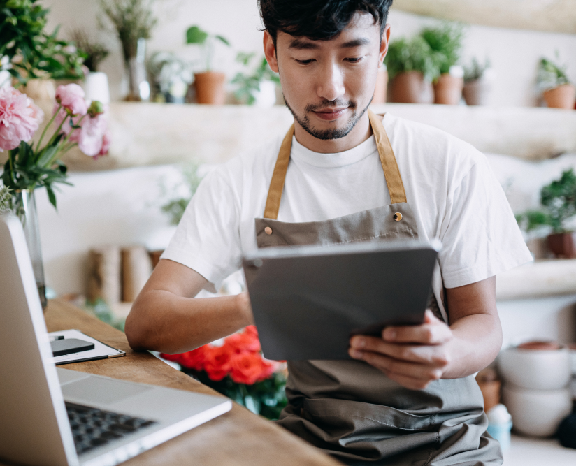 Person working in a flower show on a tablet.