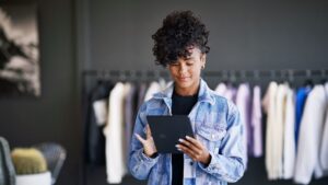 A woman holding a tablet in a retail store.