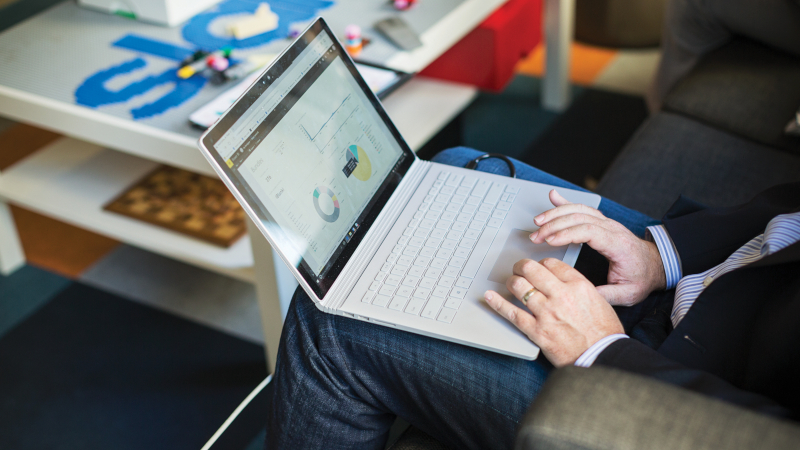 Ein Mann arbeitet mit seinem Laptop auf dem Schoß.