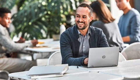 Ein Mann sitzt in einem offenen Workspace und arbeitet