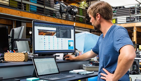 Ein Mann sitzt an einem Schreibtisch und arbeitet.