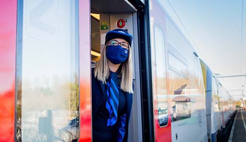 A woman who is standing at the door of a train