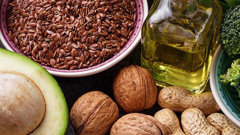 Avocado, verschiedene Nusssorten, Öl und Samen von oben fotografiert