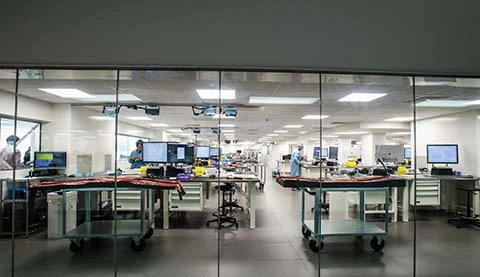 Ein steriler Produktionsraum von außen durch eine Glasscheibe.