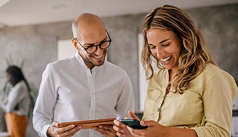 Zwei Personen blicken auf ein Tablet