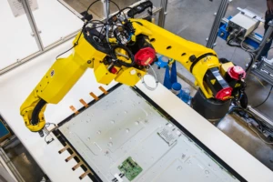 A robot in an IoT manufacturing factory building TVs. IoT infused warehouses can drive innovation.